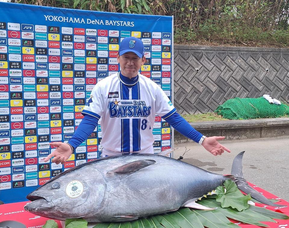 　贈呈されたクロマグロを前に、笑顔の三浦監督