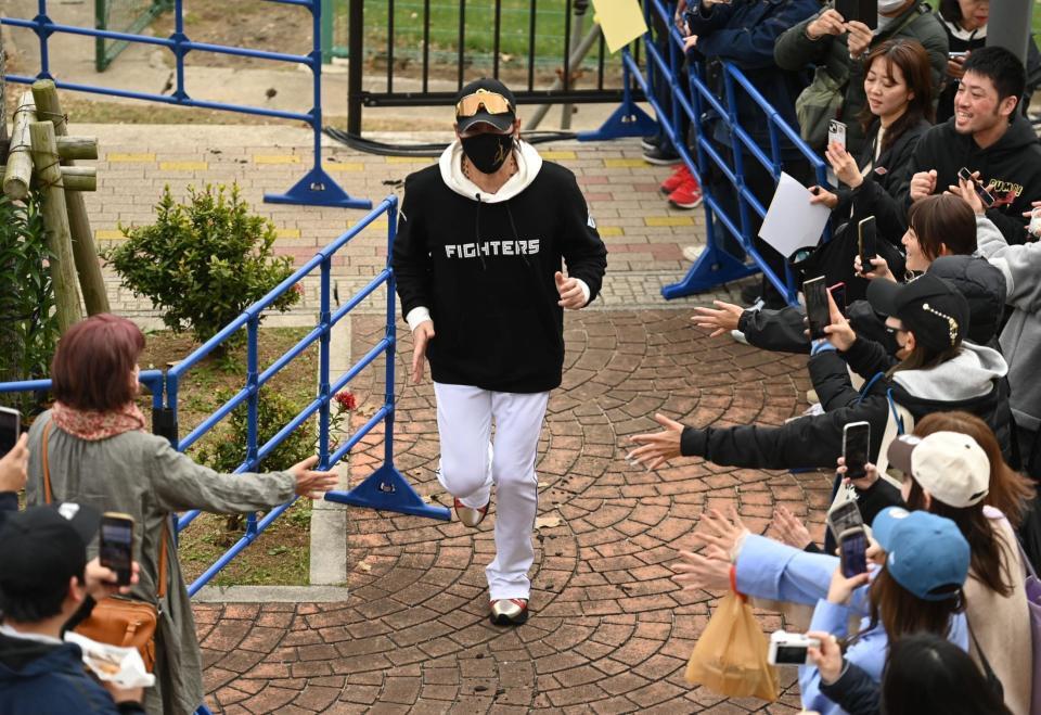 　練習の合間の移動中にファンからタッチを求められる新庄監督（撮影・開出牧）