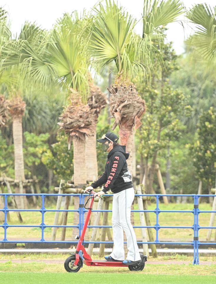 　電動キックボードで室内練習場へ移動する新庄監督（撮影・開出牧）