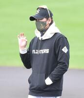 　雨にぬれたマウンドを整備するグラウンドキーパーにオーケーポーズをする新庄監督（撮影・開出牧）