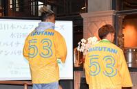 　ナゴパイナップルパークの安里清高社長（右）から贈呈されたアンバサダーの背番号入りはっぴを披露する水谷（撮影・開出牧）