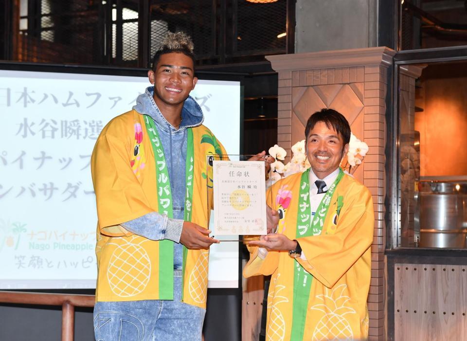　ナゴパイナップルパークの安里清高社長（右）から任命状を受け取り笑顔の水谷（撮影・開出牧）