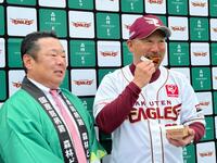 　贈呈された森林どりで作られたイーグルスからあげをほお張る三木監督（右）