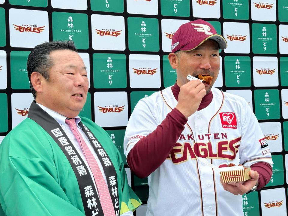 　贈呈された森林どりで作られたイーグルスからあげをほお張る三木監督（右）