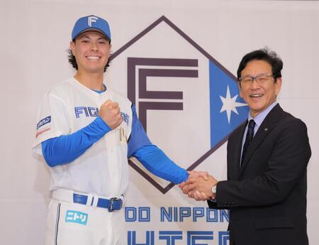 　栗山英樹ＣＢＯ（右）と笑顔で握手するマイカ与那嶺（撮影・吉澤敬太）