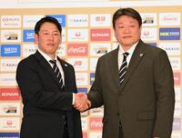　中村勝彦日本野球機構事務局長（右）とガッチリ握手を交わす侍ジャパン・井端監督（撮影・持木克友）