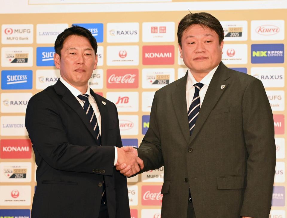 　中村勝彦日本野球機構事務局長（右）とガッチリ握手を交わす侍ジャパン・井端監督（撮影・持木克友）