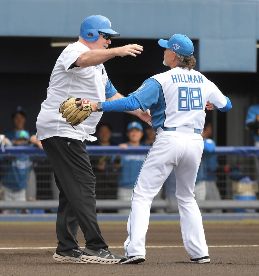 　始球式を終え、ハグするヒルマン元監督（右）とマット・ウィンタース氏（撮影・佐藤厚）