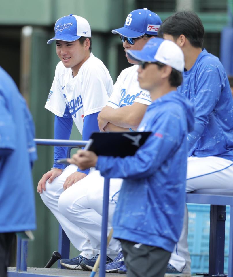 　井上監督の横に座りシート打撃を見学する金丸（左）＝撮影・吉澤敬太