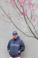 　寒緋桜が咲く下で、奥川のコンディショニング不良に表情を曇らせる高津監督（撮影・吉澤敬太）