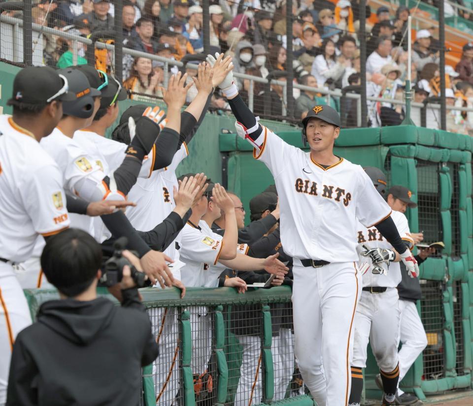 　７回、２ランを放ち、ナインとタッチを交わす秋広（撮影・西岡正）