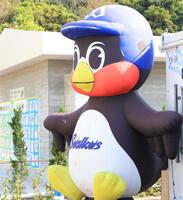 　復帰を願う子どもたちが描いた絵が並ぶ横で風に揺れる大きなつば九郎のバルーン（撮影・吉澤敬太）