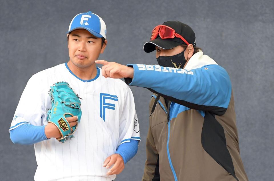 　松浦（左）にアドバイスする新庄監督（撮影・佐藤厚）