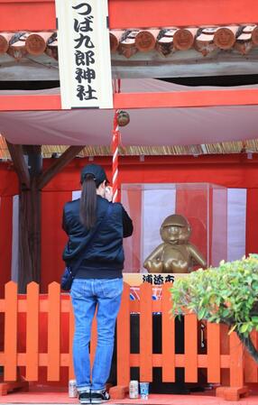 　つば九郎神社の前で、タオルで顔を覆うファン（撮影・吉澤敬太）
