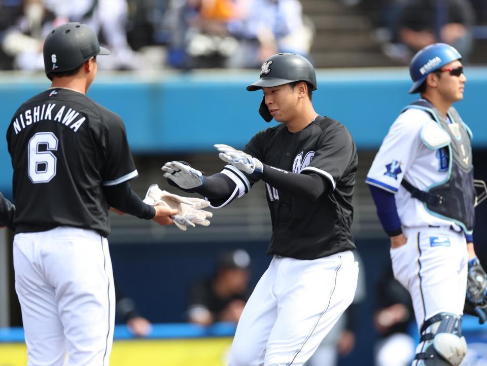 １回表、先制３ランを放ち西川に迎えられるロッテ・上田　※※　＝沖縄・宜野湾