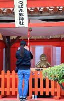 　つば九郎神社の前で、タオルで顔を覆うファン（撮影・吉澤敬太）