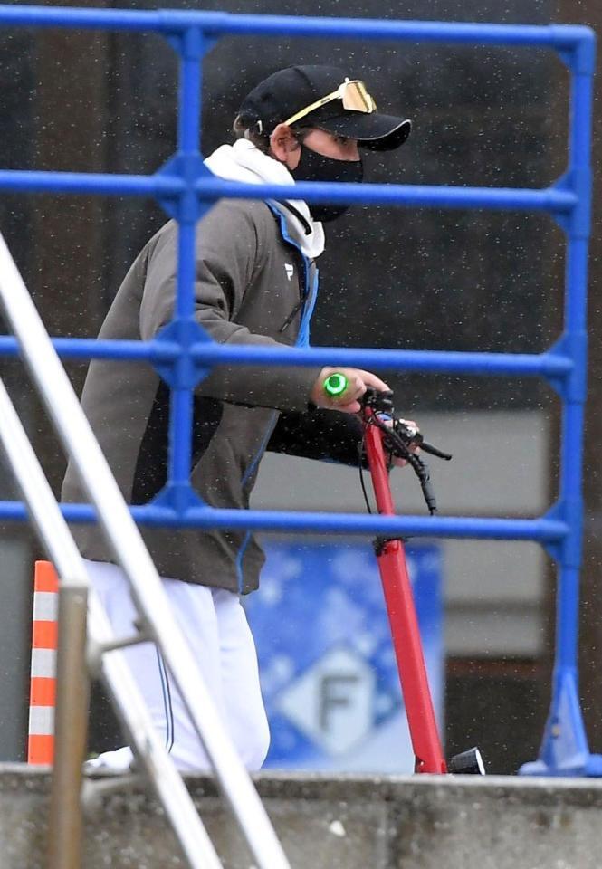 　電動キックボードで移動する新庄監督（撮影・佐藤厚）