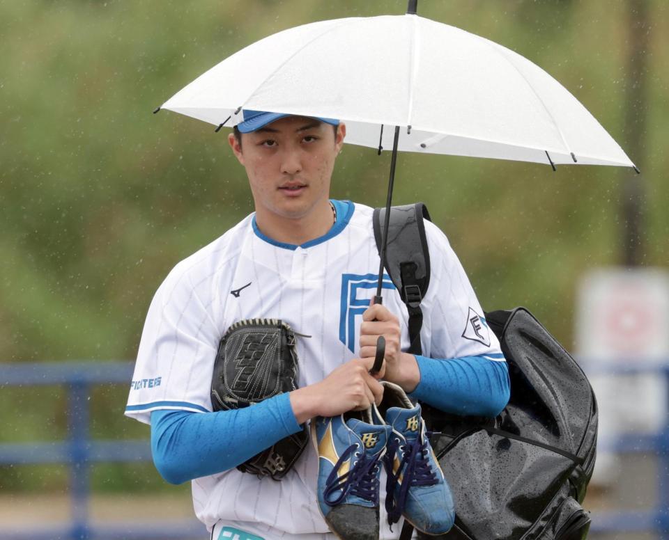 　傘を差してブルペンへ向かう柳川