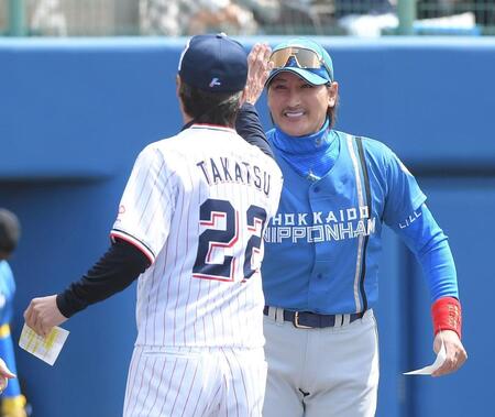 　高津監督（左）とハイタッチする新庄監督（撮影・佐藤厚）