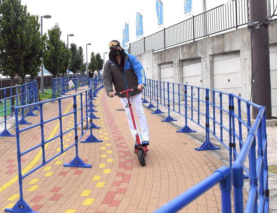 　電動キックボードで球場に向かう新庄監督（撮影・佐藤厚）