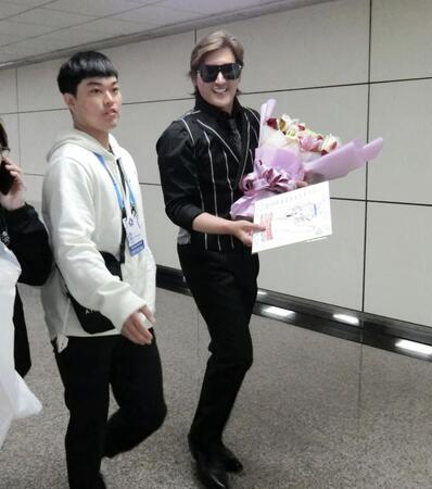 　台北に到着し、空港でファンから色紙をもらって笑顔の新庄監督（右）