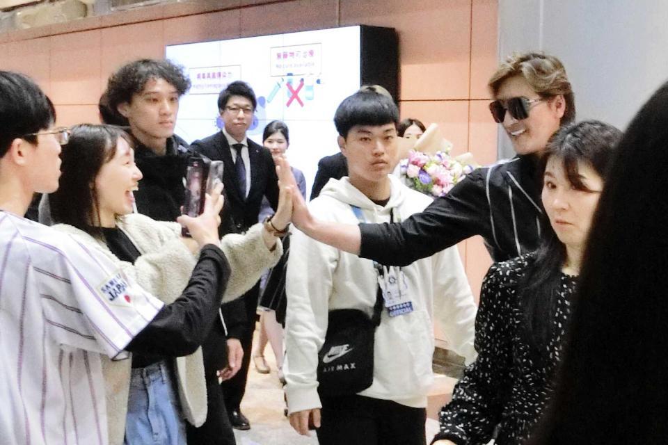 　台北に到着し、空港で出迎えたファンとタッチする新庄監督（右）＝撮影・藤田昌央