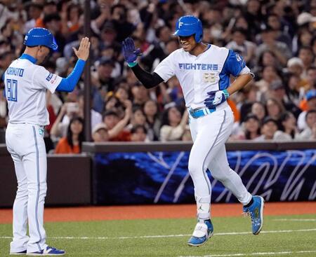 　４回、先制２ランを放ちコーチとタッチを交わす万波（右）