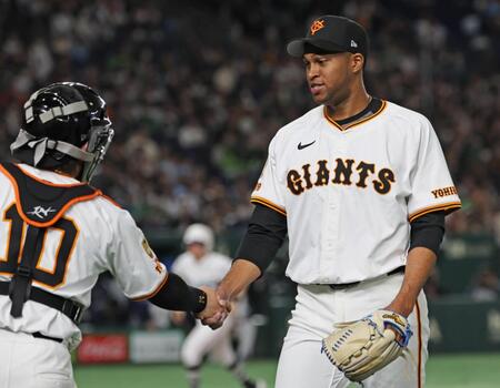 　９回に登板後、捕手・甲斐（左）と握手するマルティネス