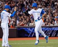 　４回、先制２ランを放ちコーチとタッチを交わす万波（右）