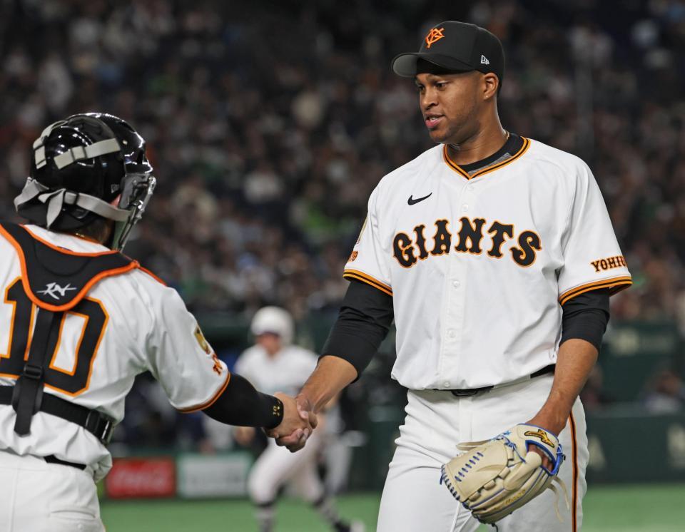 　９回に登板後、捕手・甲斐（左）と握手するマルティネス