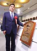 　星野仙一さんのレリーフと記念撮影する山本昌＝野球殿堂博物館