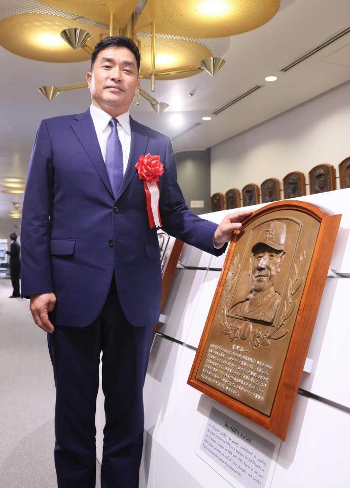 　星野仙一さんのレリーフと記念撮影する山本昌＝野球殿堂博物館