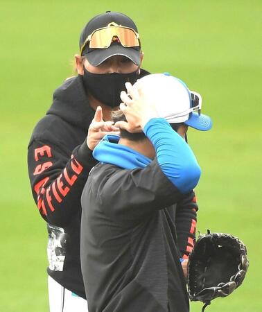 　水野（左）の後ろ髪を触る新庄監督（Ｅｎａｇｉｃスタジアム名護）＝２月２４日