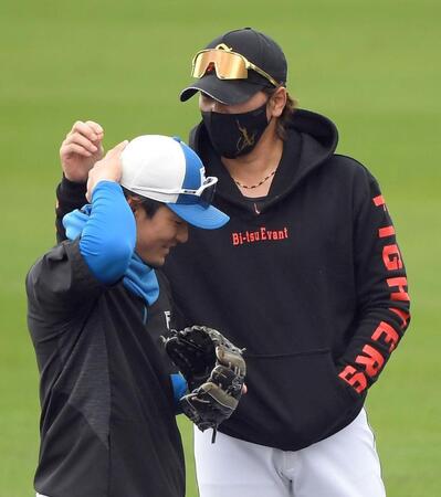 　水野（左）の襟足を触る新庄監督（Ｅｎａｇｉｃスタジアム名護）＝２月２４日