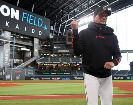 　練習前、新しく変更された内野の人工芝について語る新庄監督（撮影・中島達哉）