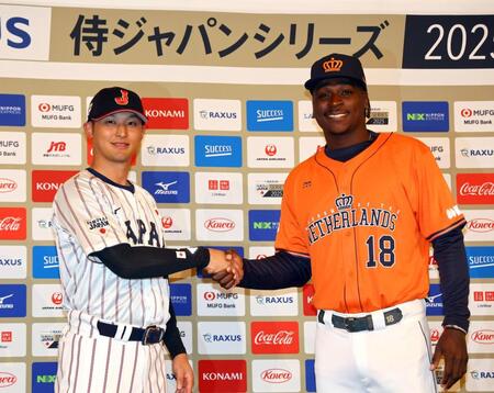 　会見を終え、握手を交わす吉川（左）とグレゴリアス（撮影・山口登）