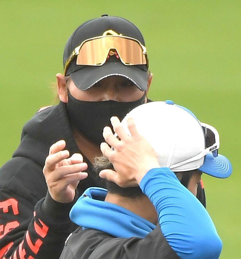 　水野（手前）の後ろ髪を触る新庄監督（Ｅｎａｇｉｃスタジアム名護）＝２月２４日