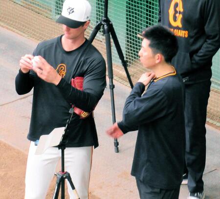 　ブルペンでグリフィン（左）と話をする戸郷