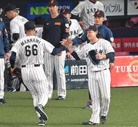 　２回、笑顔で万波（６６）とタッチを交わす宮城（撮影・飯室逸平）