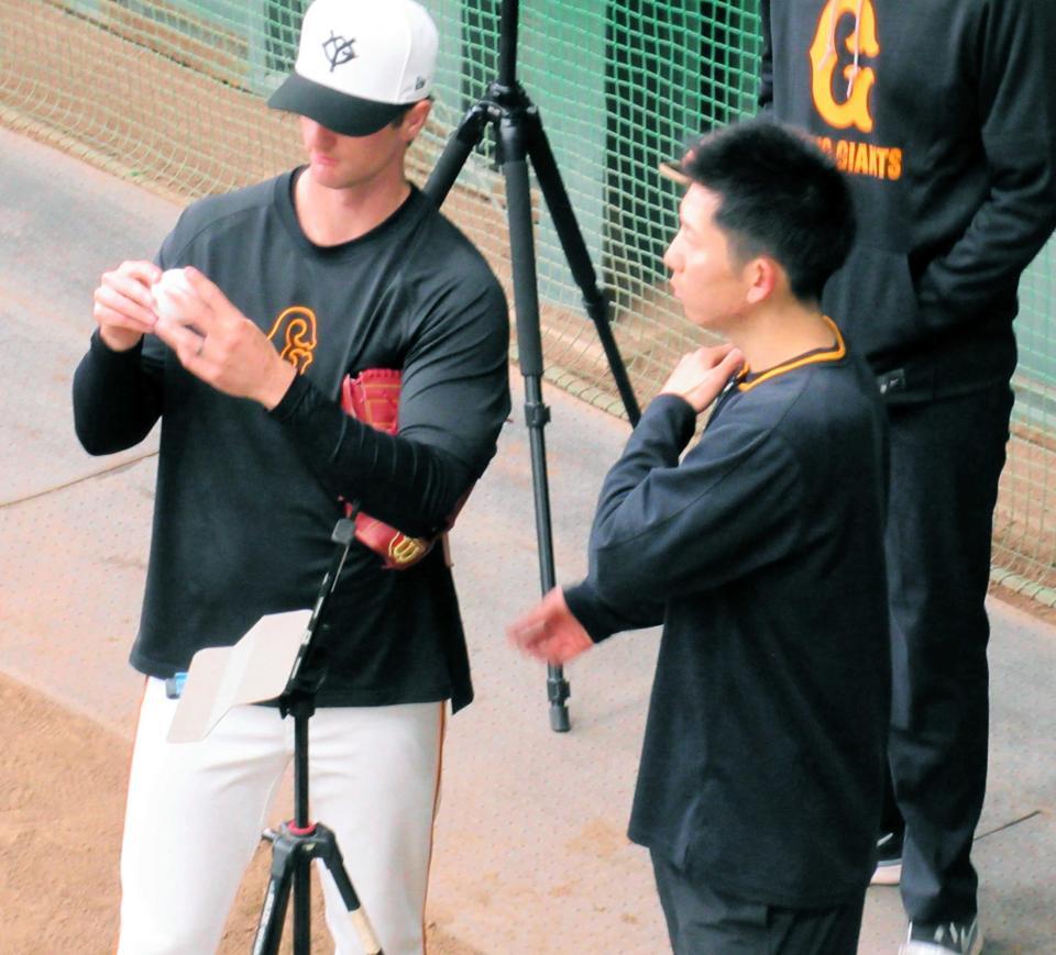 　ブルペンでグリフィン（左）と話をする戸郷