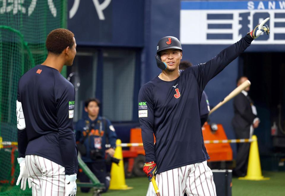 　万波（左）と談笑する佐藤輝（撮影・山口登）