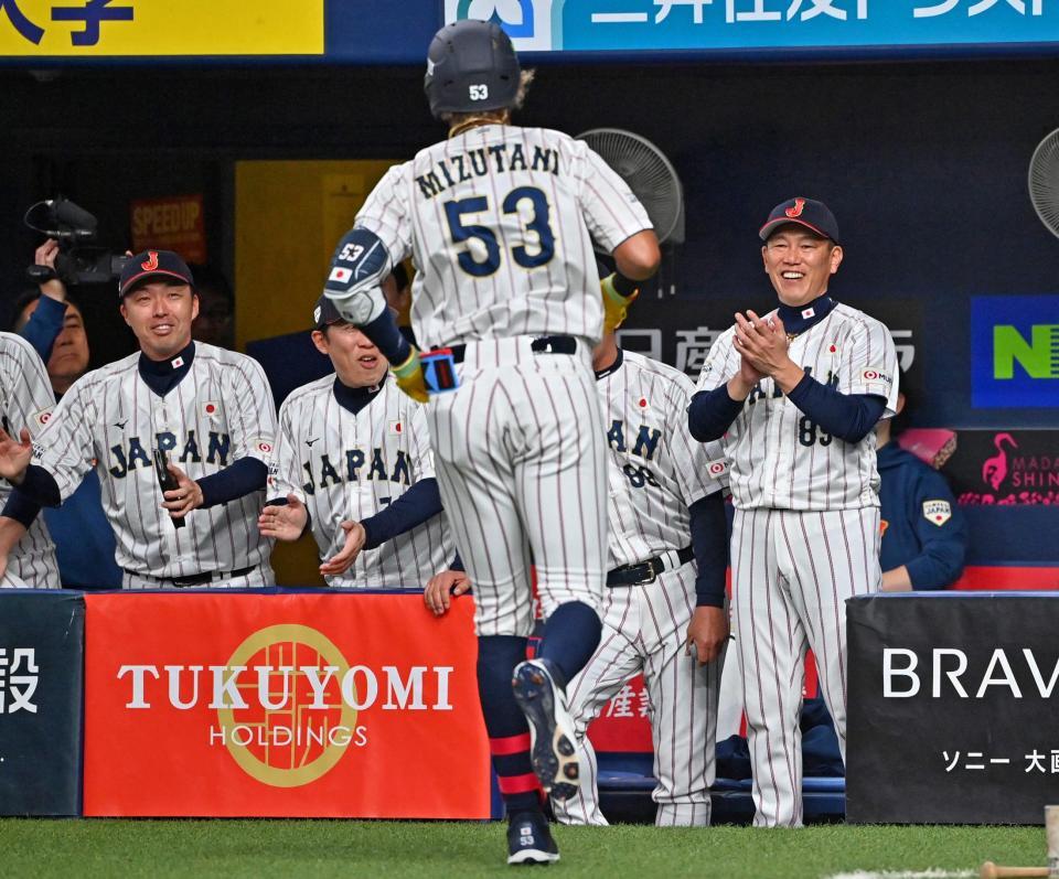 　１回裏、先制ソロを放った水谷（手前）迎える井端監督（右端）ら