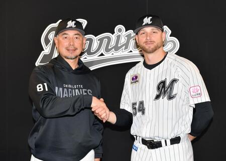 　入団会見で吉井監督（左）と握手を交わす新外国人ボス（撮影・開出牧）