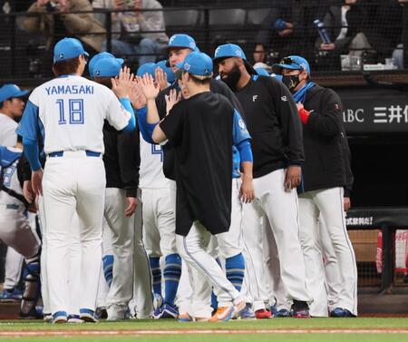 　西武に連勝し、山崎（１８）らナインを迎える新庄監督（右）＝撮影・中島達哉