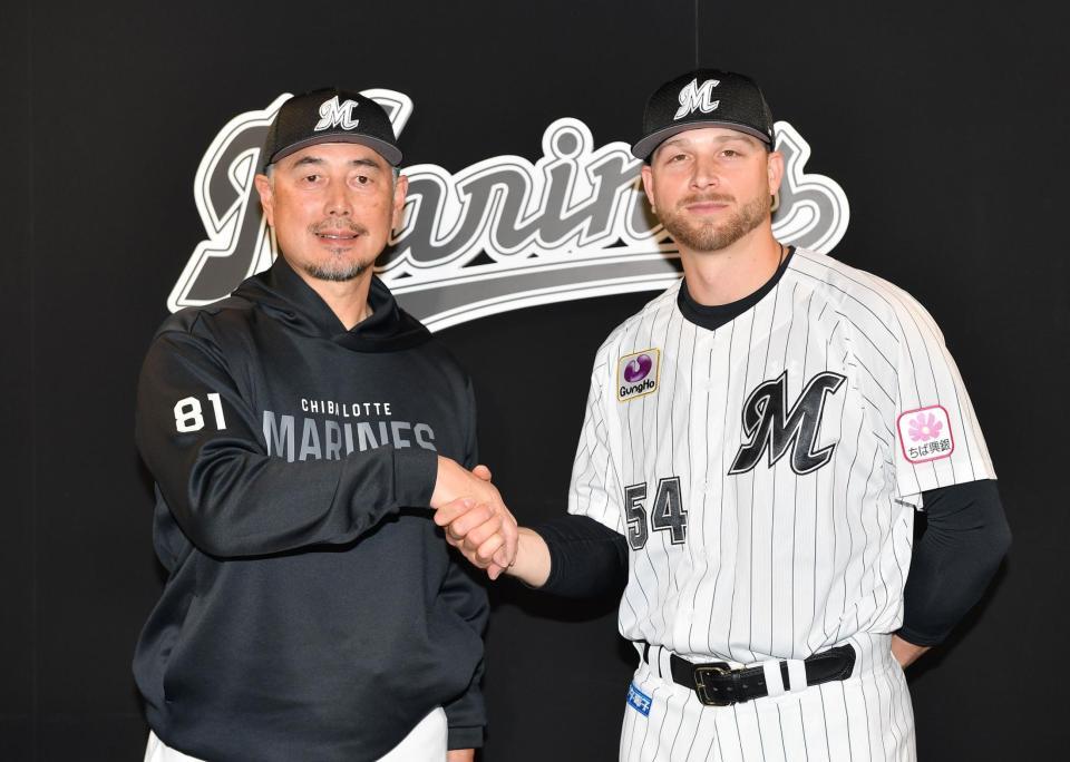 　入団会見で吉井監督（左）と握手を交わす新外国人ボス（撮影・開出牧）