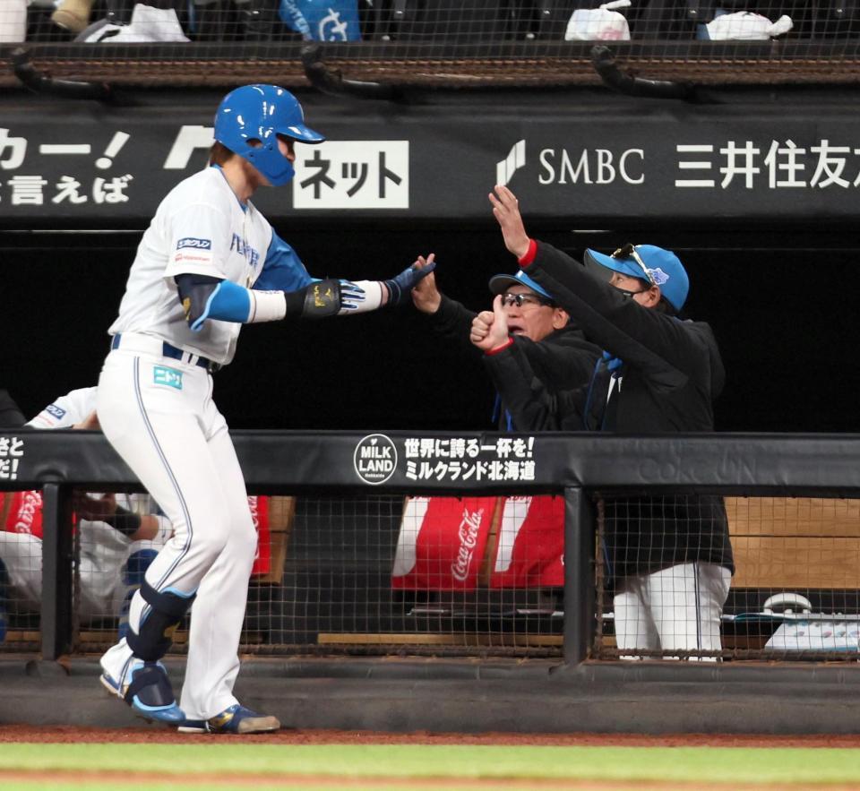 　１回、先制点をあげた山崎（左）を迎える新庄監督（撮影・中島達哉）