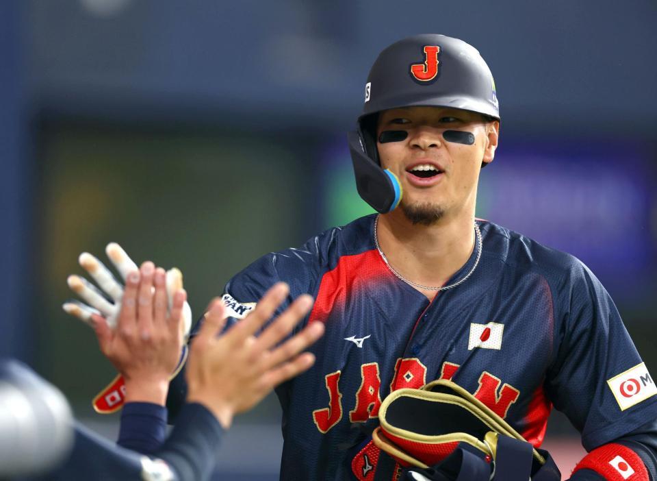 　５回、交代しベンチのナインに迎えられる佐藤輝（撮影・山口登）