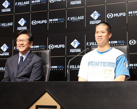 　支配下登録され、笑顔を見せる松岡（右）と栗山ＣＢＯ（撮影・中島達哉）