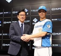 　支配下登録され、栗山英樹ＣＢＯ（左）と握手を交わす松岡（撮影・中島達哉）