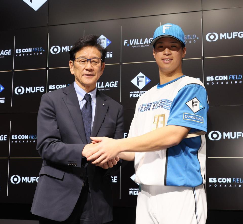 　支配下登録され、栗山英樹ＣＢＯ（左）と握手を交わす松岡（撮影・中島達哉）